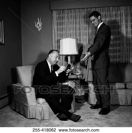 Two men in living room View Large Photo Image Stock Image - Two men in living room. Fotosearch