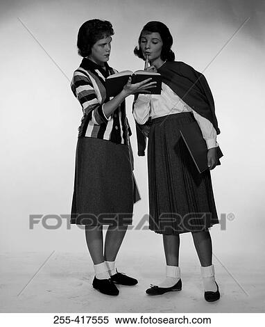 Two schoolgirls looking at book View Large Photo Image Stock Photography - Two schoolgirls looking at book. Fotosearch