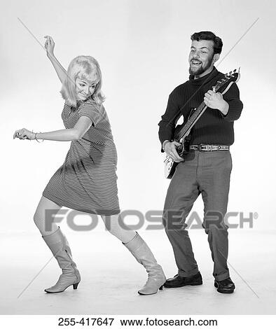 Stock Photo - Woman dancing to man playing guitar. Fotosearch