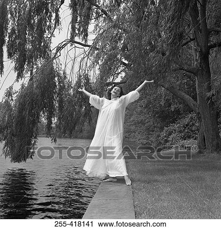 Woman in long dress standing on pool edge View Large Photo Image Stock Image - Woman in long dress standing on pool edge. Fotosearch