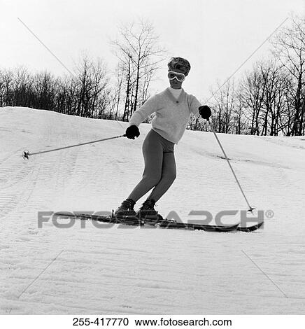 Stock Image - Woman in ski goggleskiing. Fotosearch