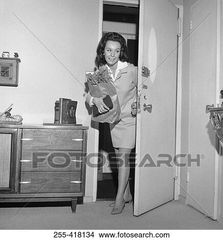 Picture - Woman opening door. Fotosearch