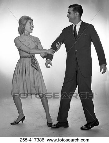 Stock Photograph - Woman pulling man, studio shot. Fotosearch