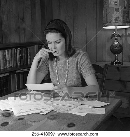 Woman riding papers by table View Large Photo Image Stock Photo - Woman riding papers by table. Fotosearch
