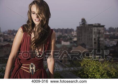 Stock Photograph - Woman sitting on a rooftop, Manhattan, New York City, New York State, USA. Fotosearch