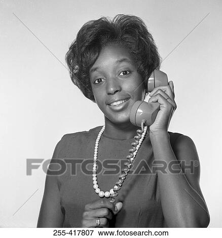 Young African-American woman holding receiver, studio shot View Large Photo Image Stock Photo - Young African-American woman holding receiver, studio shot. Fotosearch