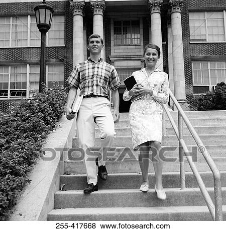 Stock Photo - Young couple carrying books on steps outside university. Fotosearch