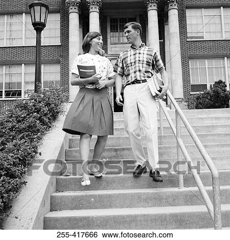 Young couple carrying books on steps outside university View Large Photo Image Stock Photograph - Young couple carrying books on steps outside university. Fotosearch
