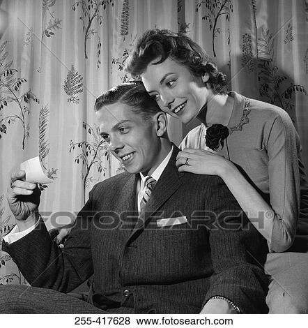 Young couple reading message by curtains View Large Photo Image Stock Photo - Young couple reading message by curtains. Fotosearch