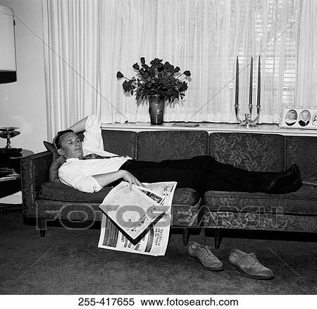 Young man sleeping on sofa in living room View Large Photo Image Stock Photography - Young man sleeping on sofa in living room. Fotosearch