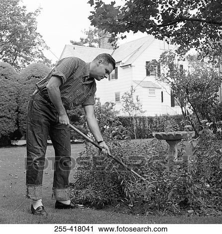 Stock Image - Young man working in garden. Fotosearch
