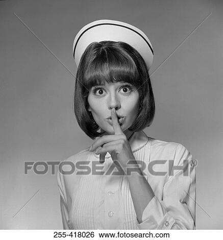 Stock Photograph - Young nurse with finger on lips. Fotosearch