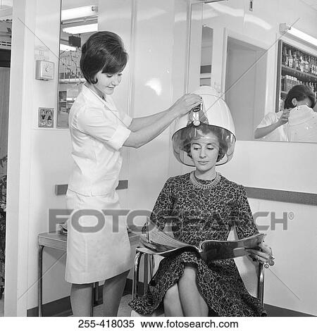 Stock Photography - Young woman and beautician in hair salon. Fotosearch