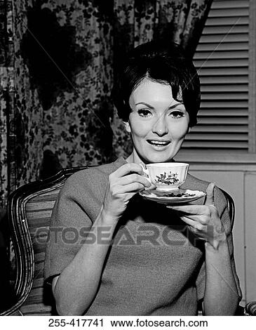 Young woman enjoying cup of tea View Large Photo Image Stock Image - Young woman enjoying cup of tea. Fotosearch