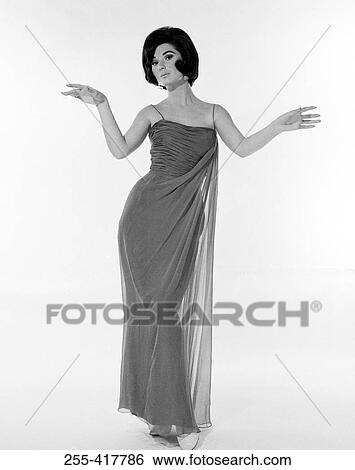 Young woman in evening dress, studio shot View Large Photo Image Stock Photograph - Young woman in evening dress, studio shot. Fotosearch