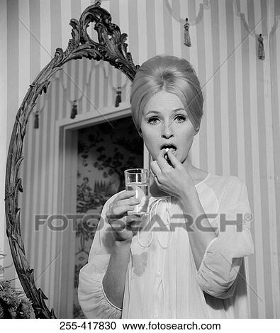 Young woman in nightwear taking pill View Large Photo Image Stock Image - Young woman in nightwear taking pill. Fotosearch