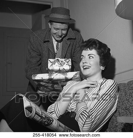 Young woman receiving presents from young man View Large Photo Image Picture - Young woman receiving presents from young man. Fotosearch