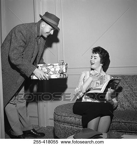 Stock Photography - Young woman receiving presents from young man. Fotosearch
