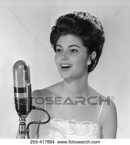 Young woman singing into microphone View Large Photo Image Picture - Young woman singing into microphone. Fotosearch