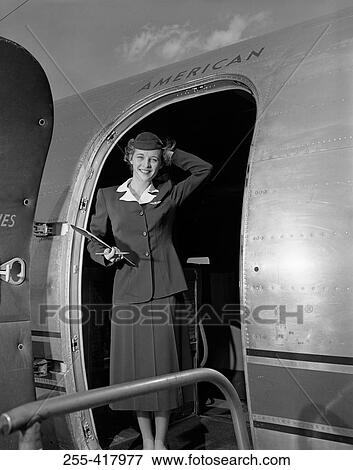 Stock Photo - Young woman standing in aiplane door and smiling. Fotosearch