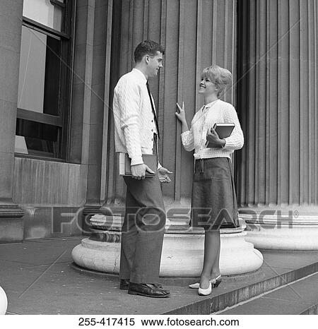 Young woman talking with man and holding book View Large Photo Image Stock Photography - Young woman talking with man and holding book. Fotosearch