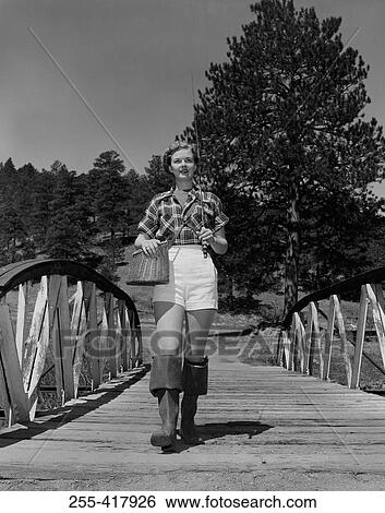 Young woman wearing wellingtons, carrying fishing rod and basket View Large Photo Image Stock Photograph - Young woman wearing wellingtons, carrying fishing rod and basket. Fotosearch