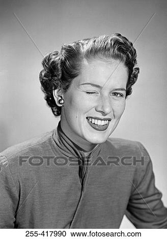 Stock Image - Young woman winking ad smiling, portrait. Fotosearch