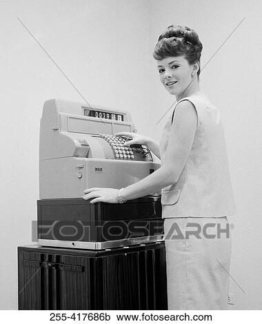 Stock Image - Young woman working on till. Fotosearch