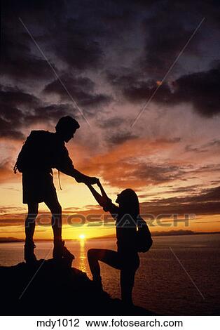 Couple hiking sunset silhouette overlooking Cook Inlet 