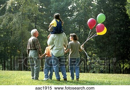 後ろからの光景 の ３世代 の A 家族 で 祖父 親 そして ３人の子供たち 公園の中を歩く で Balloons ストックフォト 写真素材 c1915 Fotosearch
