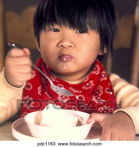 Stock Photo of Portrait of an Asian child eating a bowl of vanilla ice ...