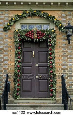 Close Up Of A Front Door With A Holiday Garland Of Green Leaves