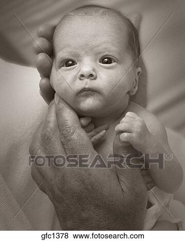 Close-up portrait of a newborn baby being held in an adult ...
