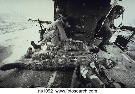 Salvadoran Medic Tends To Wounded Soldiers As Door Gunners Watch