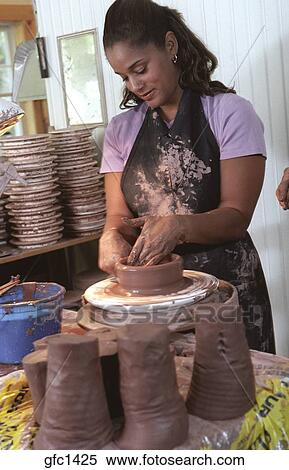 Woman Begins To Turn A Lump Of Clay Spinning On A Pottery Wheel Into A Bowl Wheels Clay Cylinders Fill The Potter S Workshop Stock Photography Gfc1425 Fotosearch