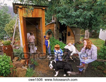 Kids and Mom waiting to use family dunny or outhouse in Tasmania Stock