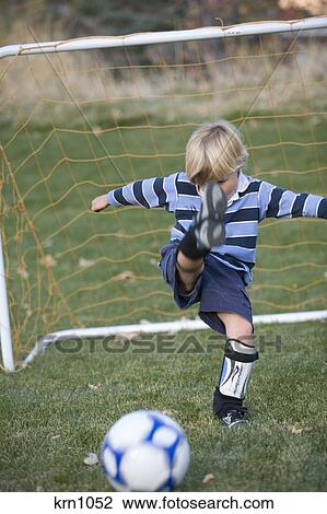 Little Blond Boy Kicking A Soccer Ball With All His Might In Front Of The Goal Stock Image Krn1052 Fotosearch