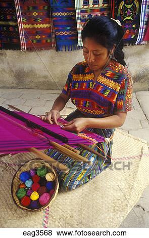 INDIGENOUS WOMAN with traditional BACKSTRAP LOOM weaving a HUIPIL, a ...