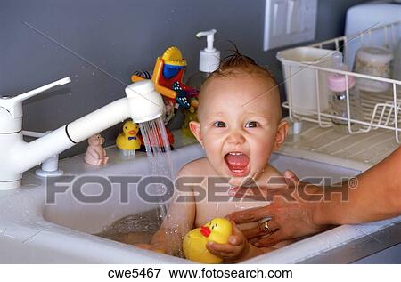 Mom Bathing Baby 6 12 Months Old In Kitchen Sink Stock Photo