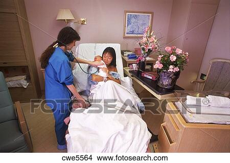 nurse tending to mother and newborn baby in hospital recovery room nurse