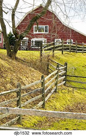 Farm Scene With Red Barn In Background And Wood Fence Leading Into
