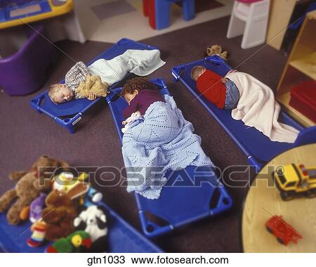 Children Sleeping On Floor Mats At A Daycare Center Stock Image