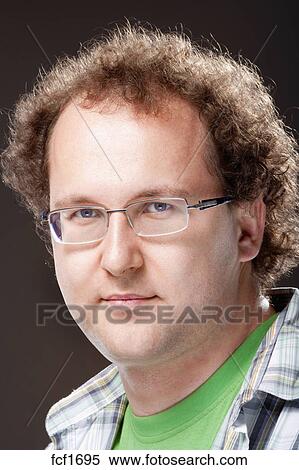Portrait Of A Young Man With Curly Hair And Glasses Isolated On