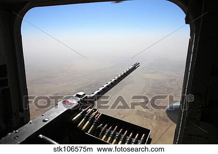 Picture - A. 50 caliber machine gun aims outboard of a CH-53E Super Stallion.. Fotosearch