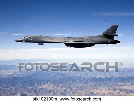 A B-1B Lancer carries the Sniper pod on its belly as it flies through the sky. View Large Photo Image Picture - A B-1B Lancer carries the Sniper pod on its belly as it flies through the sky.. Fotosearch