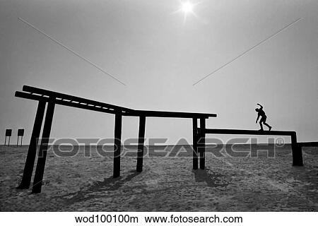 A Basic Underwater Demolition SEAL student walks across a balance beam. View Large Photo Image Picture - A Basic Underwater Demolition SEAL student walks across a balance beam.. Fotosearch