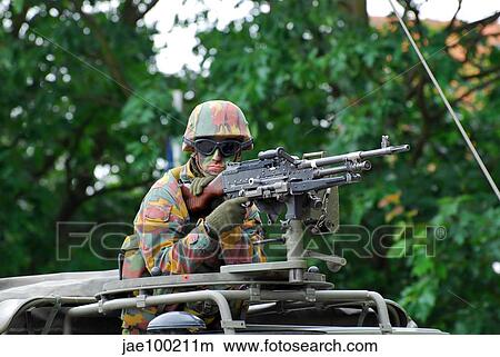 A Belgian Army soldier handling a machine gun atop a Unimog vehicle. View Large Photo Image Picture - A Belgian Army soldier handling a machine gun atop a Unimog vehicle.. Fotosearch