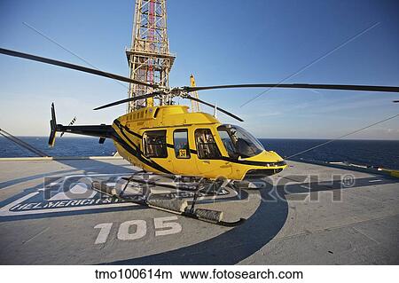 A Bell 407 utility helicopter on the helipad of an oil rig. View Large Photo Image Picture - A Bell 407 utility helicopter on the helipad of an oil rig.. Fotosearch