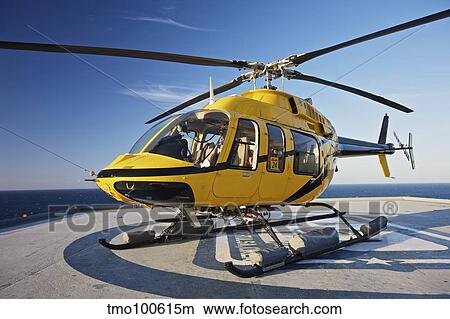 A Bell 407 utility helicopter on the helipad of an oil rig. View Large Photo Image Picture - A Bell 407 utility helicopter on the helipad of an oil rig.. Fotosearch