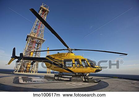 A Bell 407 utility helicopter on the helipad of an oil rig. View Large Photo Image Picture - A Bell 407 utility helicopter on the helipad of an oil rig.. Fotosearch